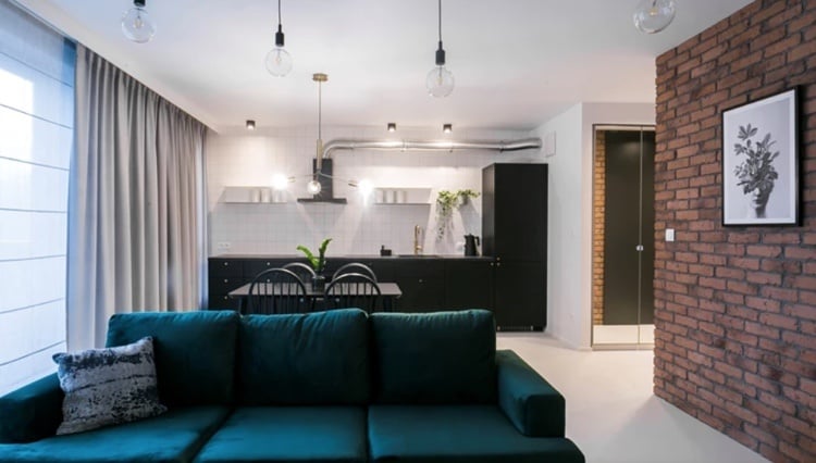 petrol grünes sofa mit hellgrauen gardinen und schwarz-weißer küche kombiniert