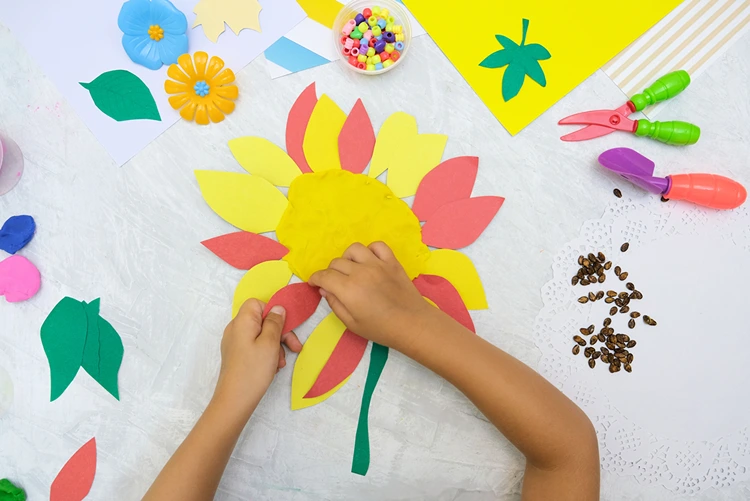 Knete kreisförmig ausbreiten und Blütenblätter aus Papier festdrücken