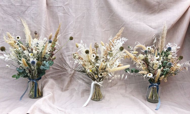 Blumenarrangements in Glasvasen mit Trockenblumen