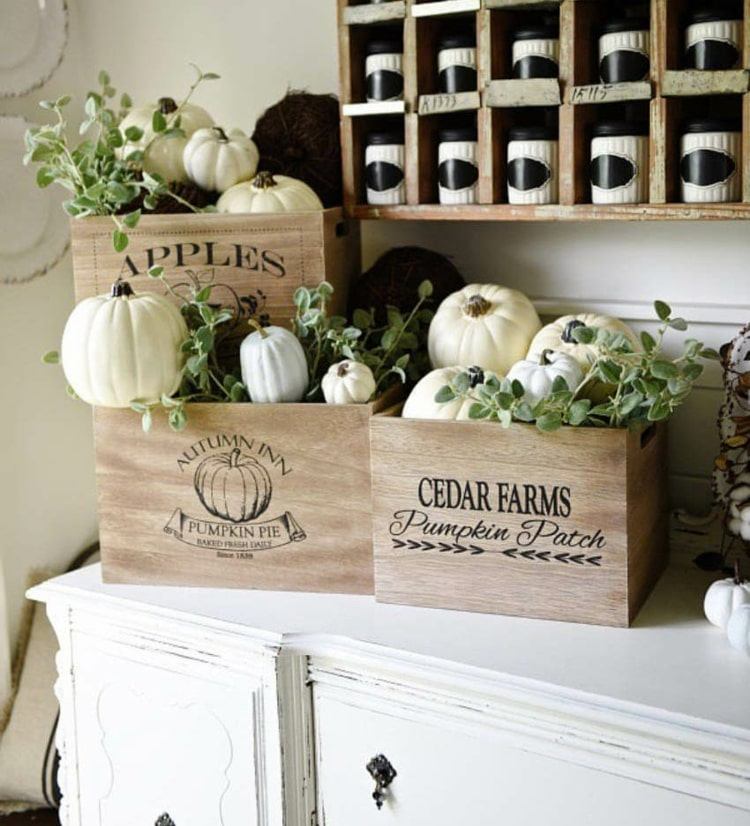 Herbstliche Dekoidee für die Küche mit kleinen Kisten und weißen Kürbissen auf einem Schrank