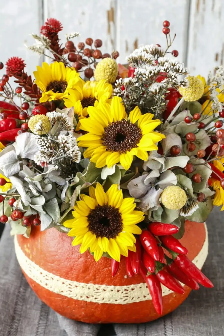 Herbstliche Trockengestecke für den Tisch mit Chili, Beeren Trockenblumen und künstlichen Sonnenblumen