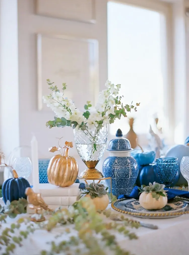 Tischdeko für den Herbst mit Vase aus Glas auf einem Tortenständer