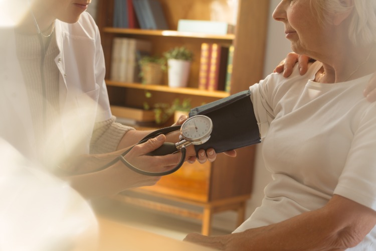 krankenschwester hilft älterer frau bei der senkung des blutdrucks