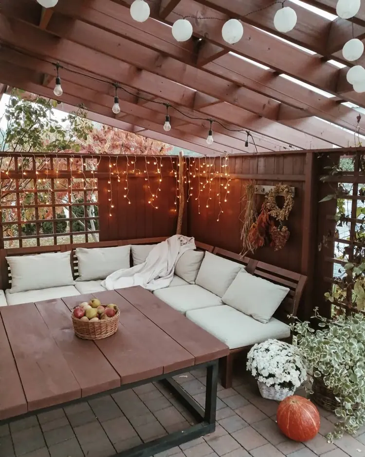 terrasse herbstlich gestalten mit lichterketten, chrysanthemen und kürbissen