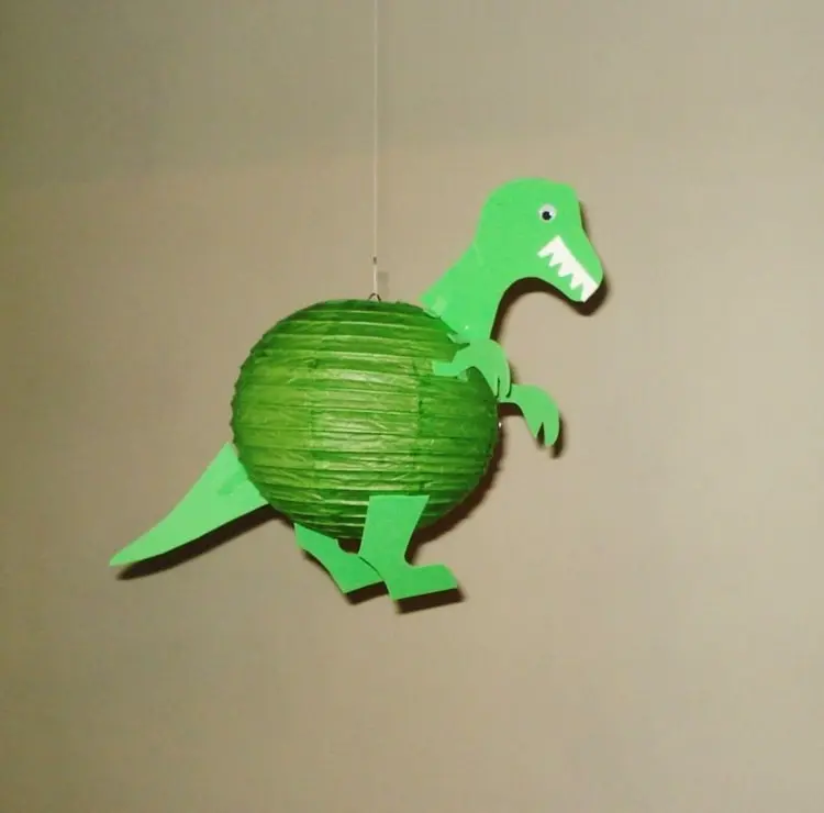Grüner T-Rex mit Partylampion aus Papier gebastelt