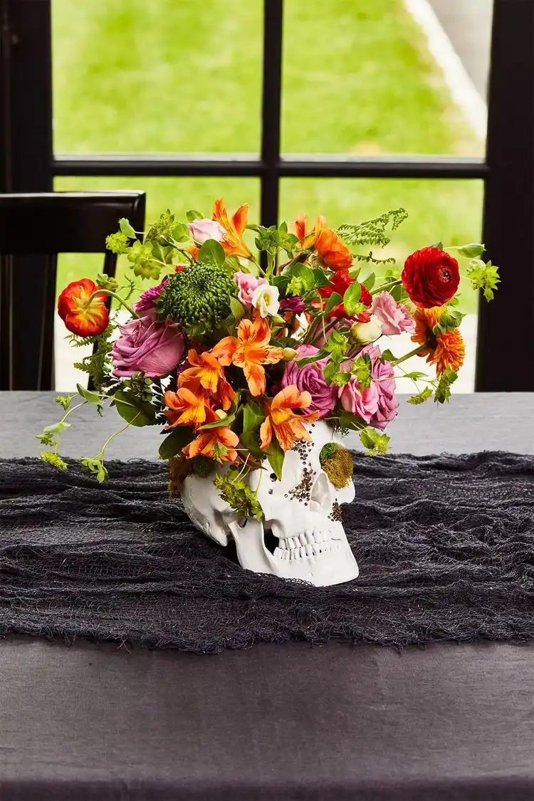 Halloween Tischdeko Vase aus Schädel mit Blumen arrangiert
