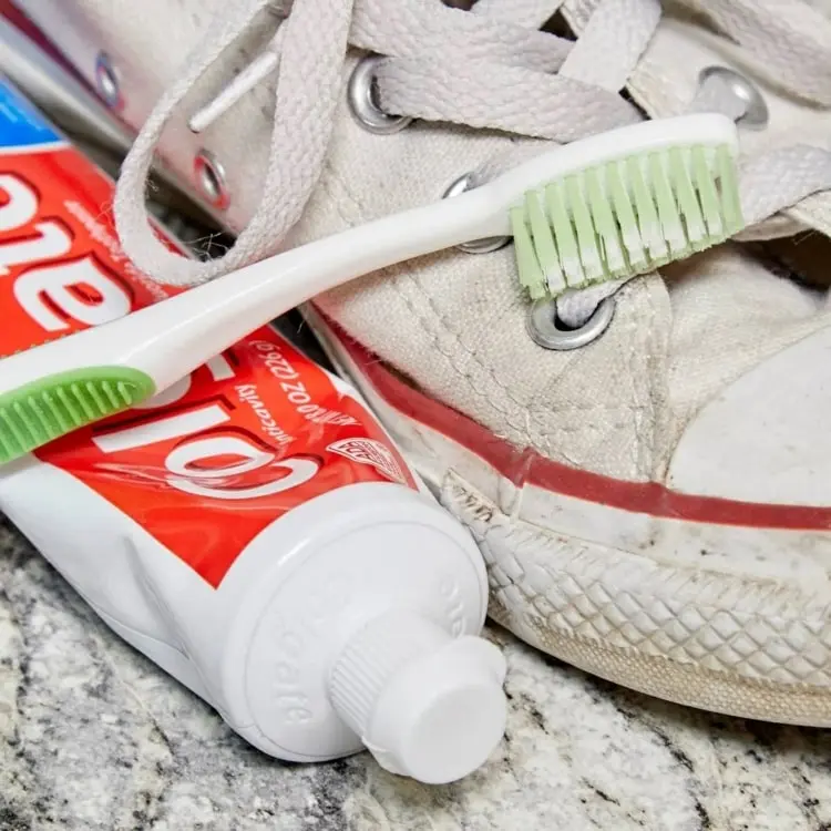 Weiße Schuhe reinigen mit Zahnpasta und einer Zahnbürste