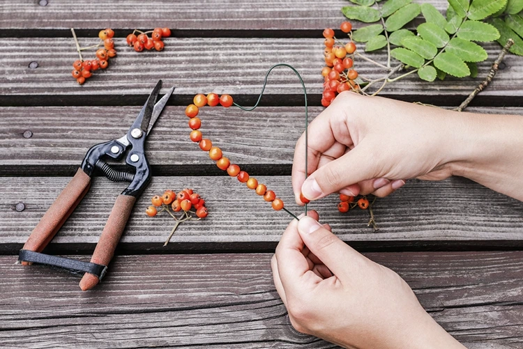 Herbstfrüchte auf Draht fädeln und ein Herz formen
