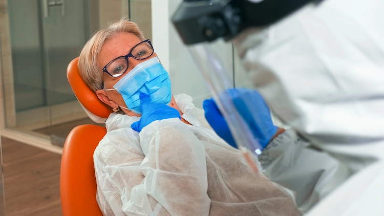patientin mit schutzmaske beim zahnarzt während covid 19 pandemie