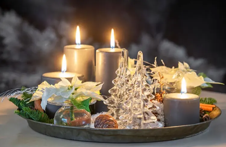 Adventskranz in Schalen mit grauen Kerzen und weißen Weihnachtssternen