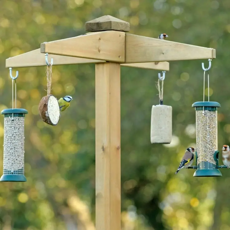Gartendeko selber bauen mit Holzbalken und -brettern zum Aufhängen von Futtersäulen für Vögel