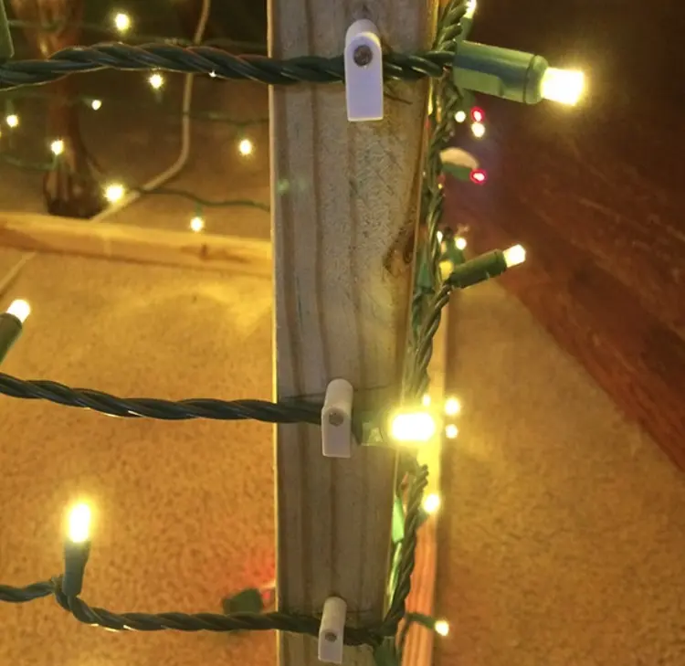Kabel der Lichterkette mit Kabelklemmen am Holz befestigen