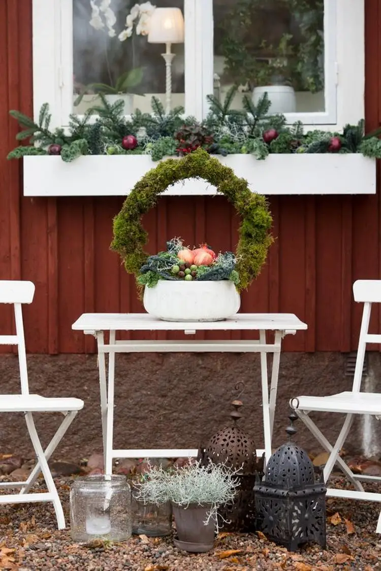 Schönes Gesteck aus Tannengrün und Moos als Deko für den Gartentisch im Winter