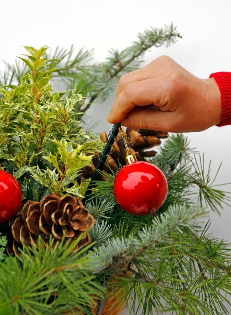 Weihnachtliche Gestecke für draußen mit Tannenzweigen und Christbaumkugeln basteln