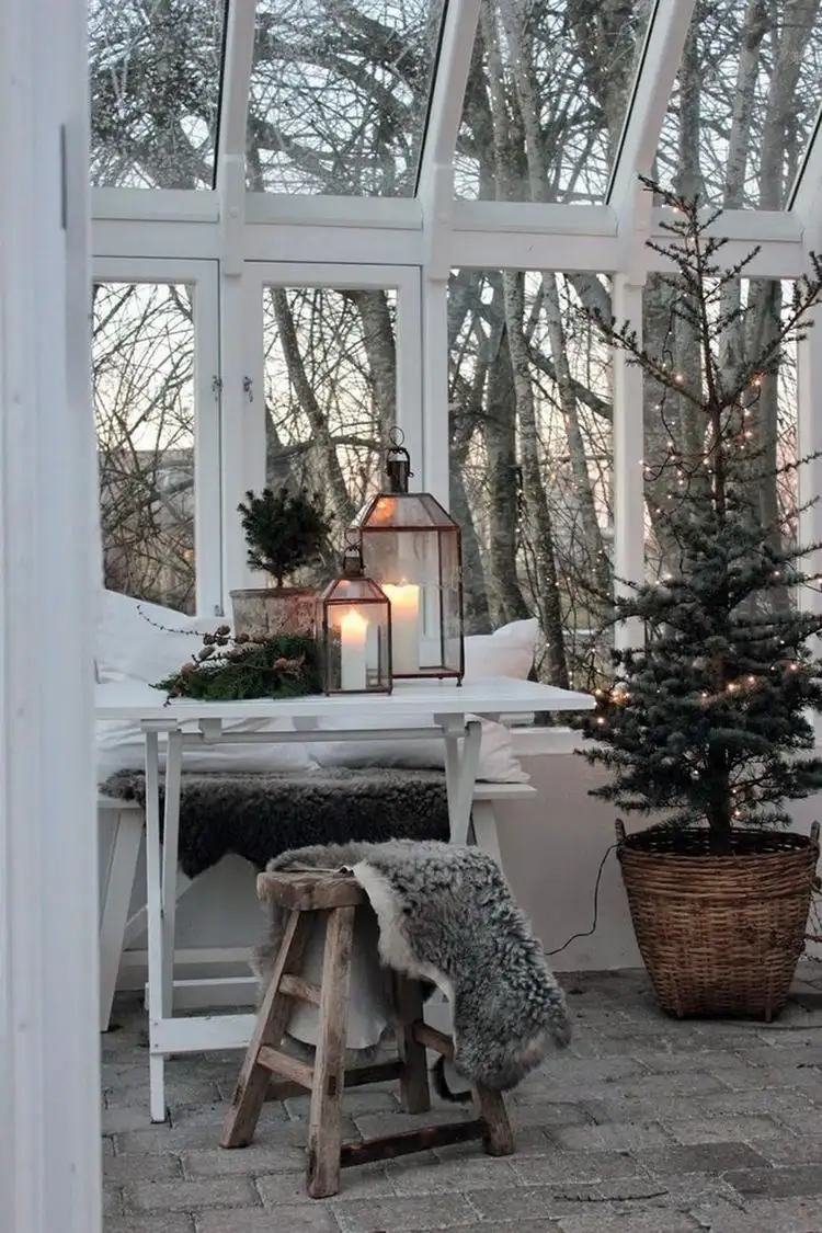 Winterdeko für überdachte Terrasse Laternen und Weihnachtsbaum im Korb