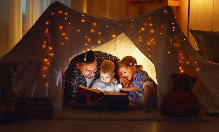 Zu Hause Bücher lesen mit Kinden im Zelt