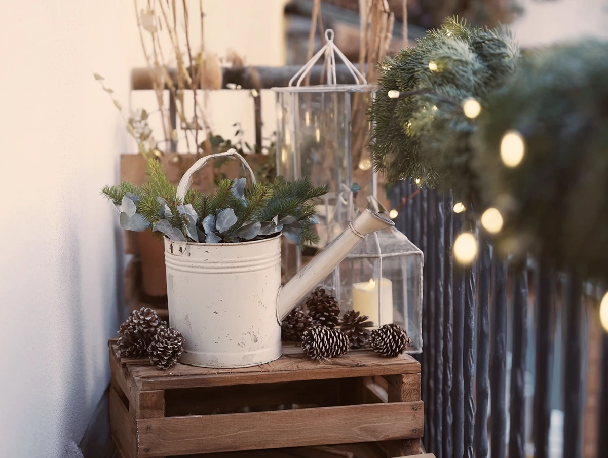 zapfen und tannenzweige in der gießkanne – einfache winterliche balkondeko
