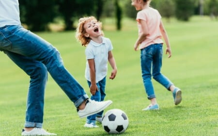 Familie spielt Fussball im Garten