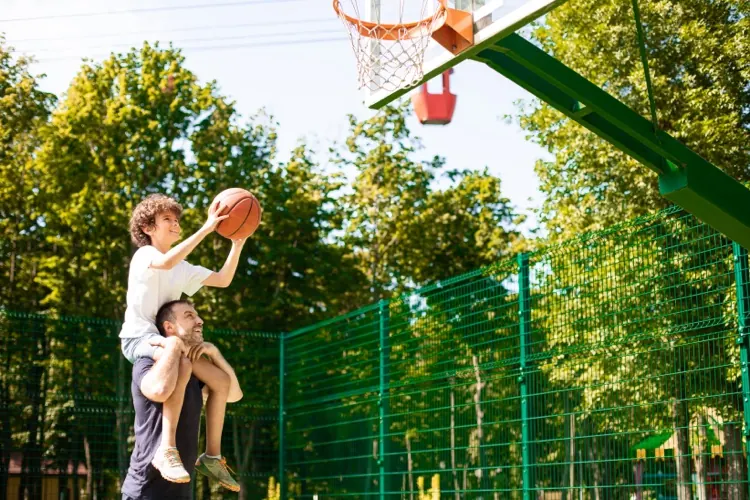 Vater und Sohn spielen Basketball im Garten