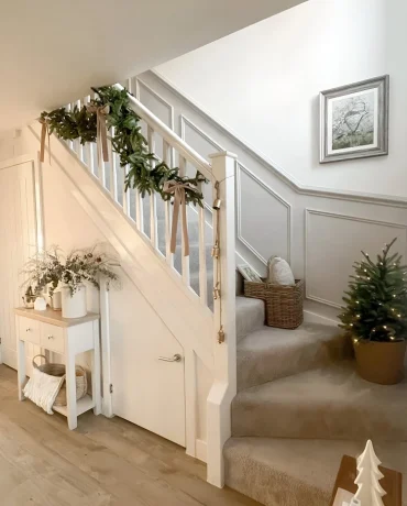 Mini-Weihnachtsbaum auf den Stufen und Tannengirlande am Geländer