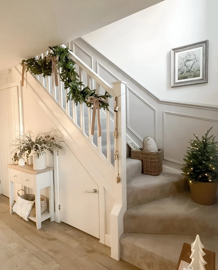 Mini-Weihnachtsbaum auf den Stufen und Tannengirlande am Geländer