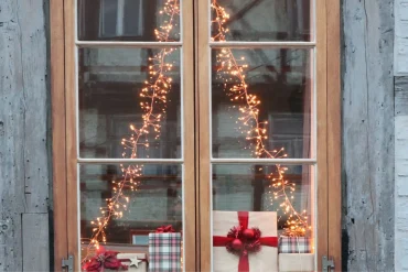mit weihnachtsbeleuchtung am fenster der weihnachtsdekoration den letzten feinschliff verleihen