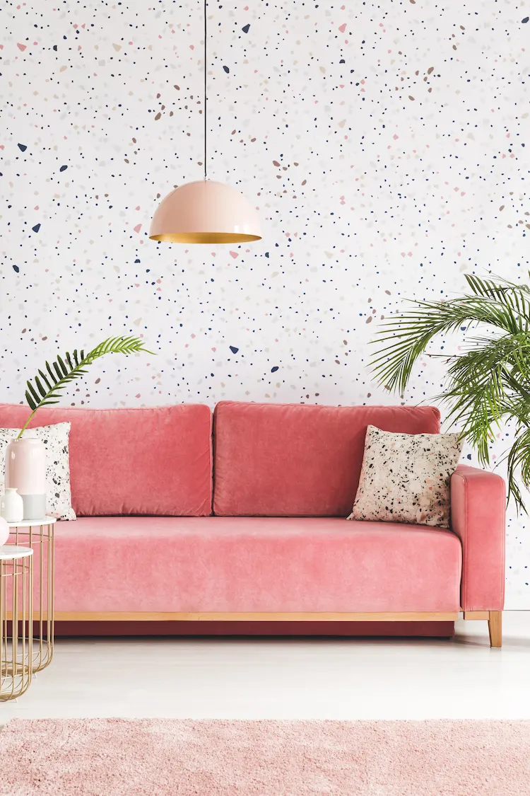 passende farben im wohnraum mit rosafarbenem sofa und kontrastierender musterwand