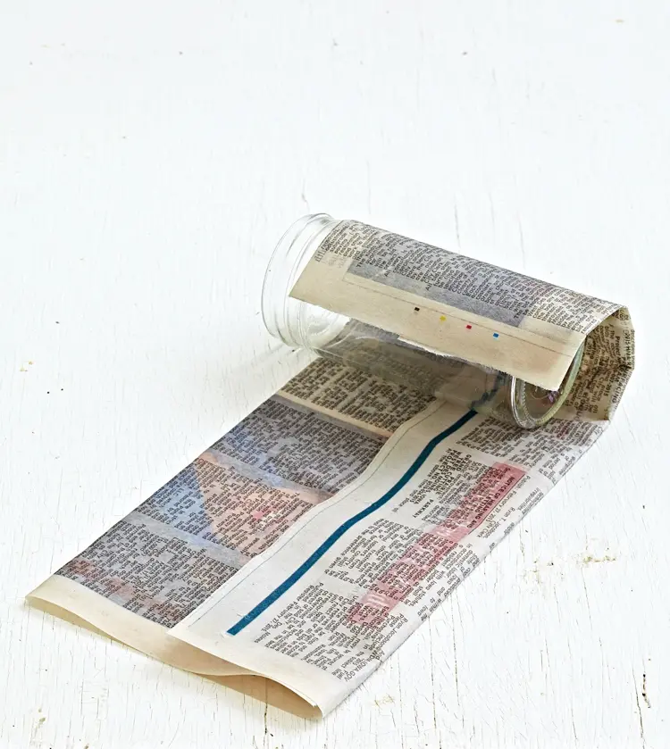 Feuchtes Zeitungspapier um Glas wickeln