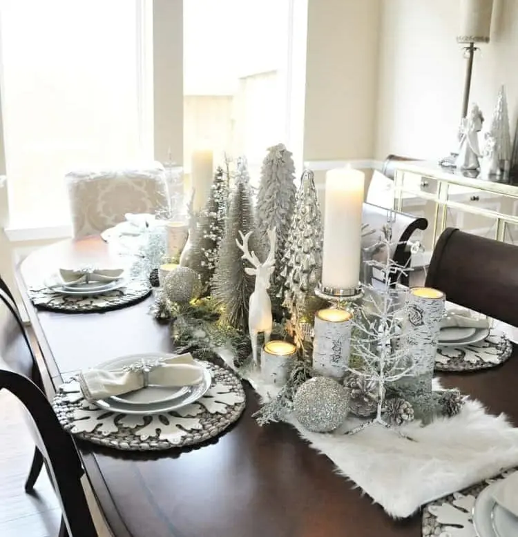 Für die Winterdeko auf dem Tisch einen kleinen Wald kreieren mit künstlichen Tannenbäumen und Hirsch