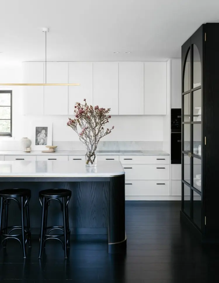 Moderne Landhausküche mit geschwungener Kücheninsel in Schwarz-Weiß als Küchentrend 2022