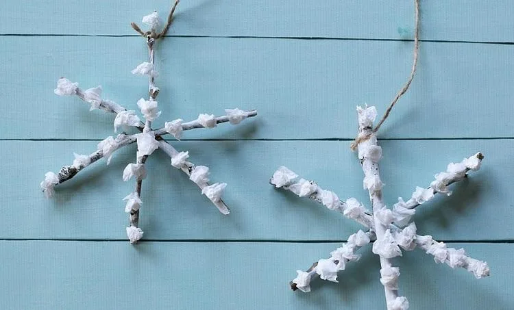 Schneeflocken basteln im Winter mit Kindern aus Zweigen und Papierschnipseln