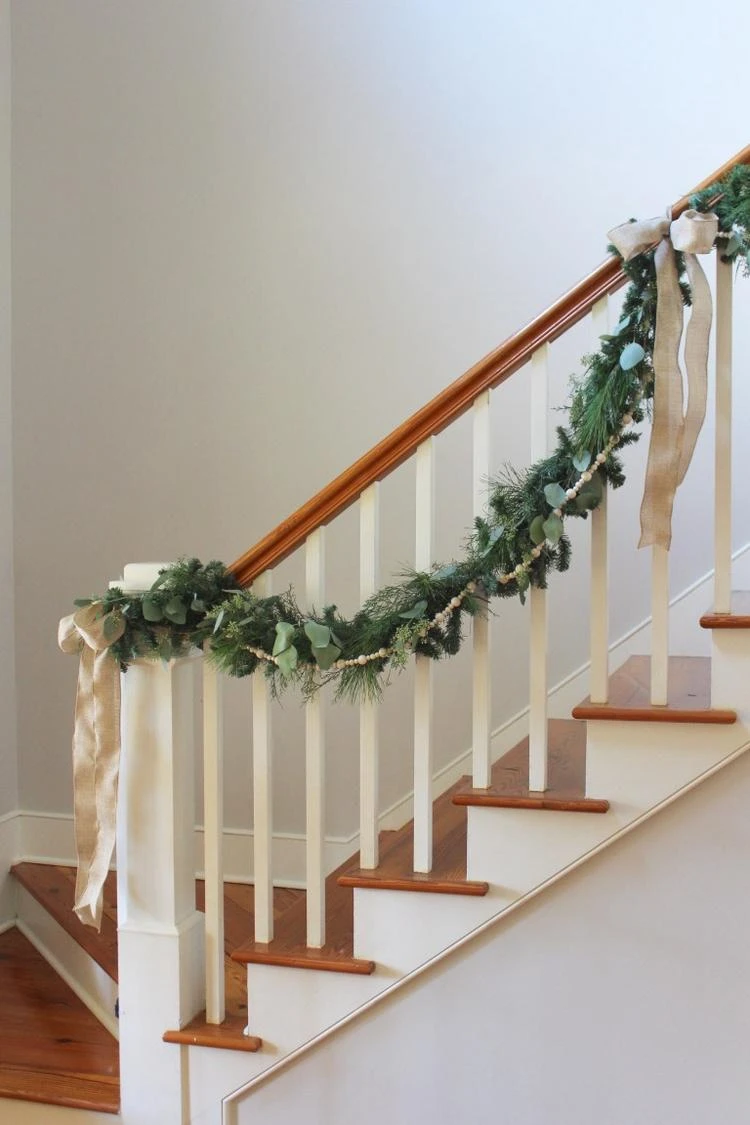 Treppengeländer winterlich dekorieren mit Wintergrün und Holzperlen