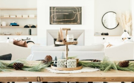 Winterdeko auf dem Tisch mit Etagere, immergrünen Zweigen und Tannenzapfen