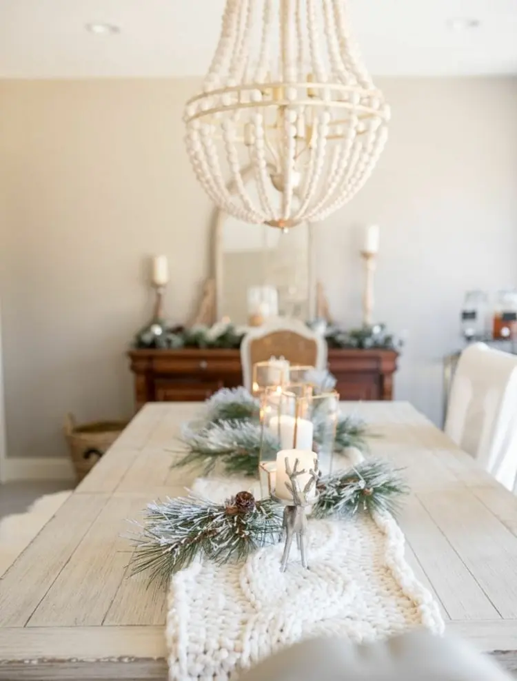 Winterdeko auf dem Tisch mit gestricktem Tischläufer und Kerzen