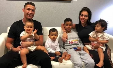 fußballspieler ronaldo mit all seiner kinder und ehefrau auf einem sofa