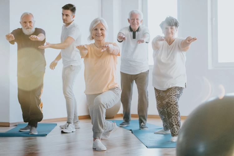 gruppe von senioren führt krankheitsgymnastik im fitnessstudio mit trainer durch