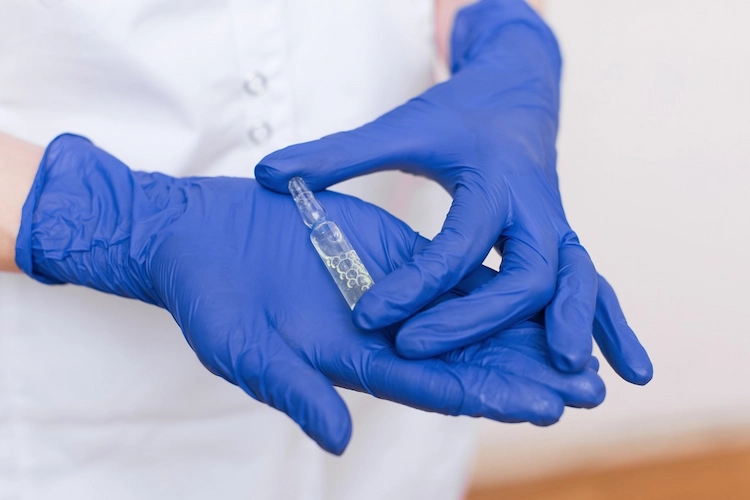 mediziner hält eine dosis mit flüssigem medikament in den händen