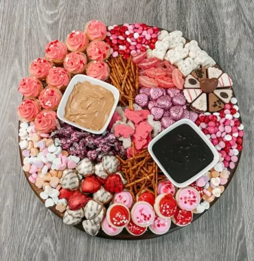 Charcuterie Boards zum Valentinstag in Rosa mit Salzstangen, Bonbons und Pralinen