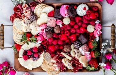 Charcuterie Boards zum Valentinstag mit Himbeeren, Crackern, Süßigkeiten und Käse
