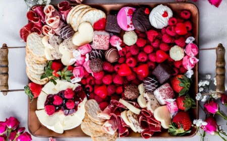 Charcuterie Boards zum Valentinstag mit Himbeeren, Crackern, Süßigkeiten und Käse