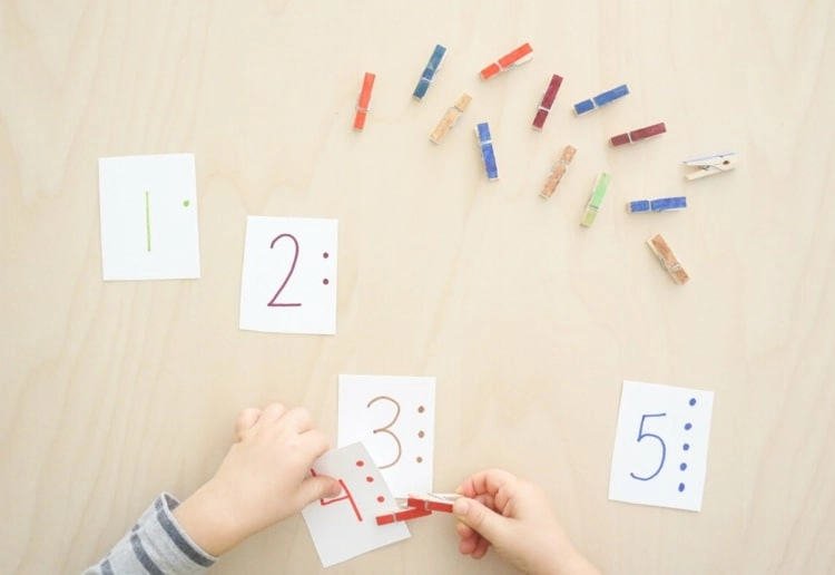 Lernspiele für Kinder - Zählen üben mit Wäscheklammern und Papier im Kindergarten