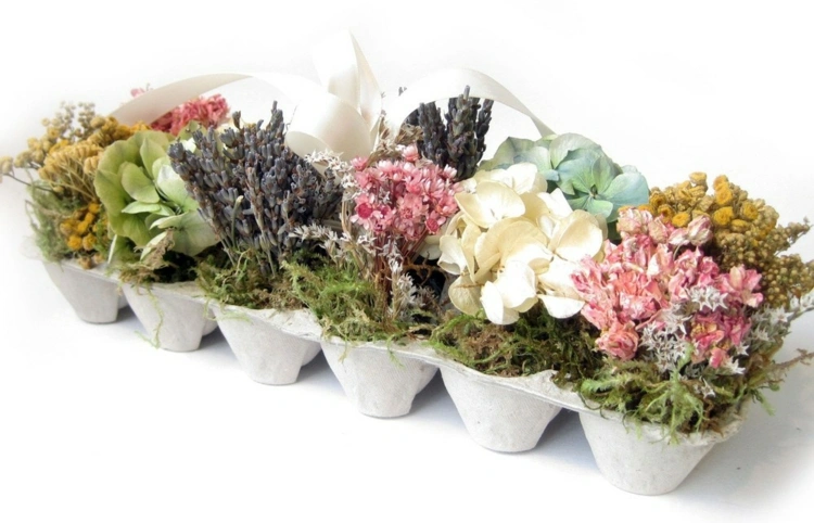 Arrangement mit Trockenblumen und Moos in Eierpappen