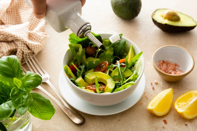 blattgemüse und avocado als salat mit olivenöl für mehr omega 3 fettsäuren abschmecken
