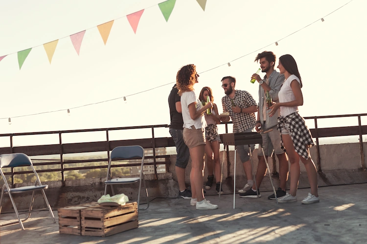 junge menschen beim feiern von grillparty auf einer terrasse
