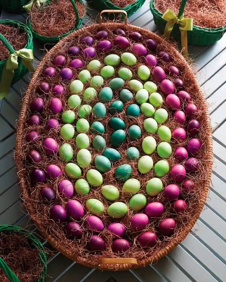 Ein flacher Korb mit bunten Eiern gefüllt als Deko für den Hauseingang