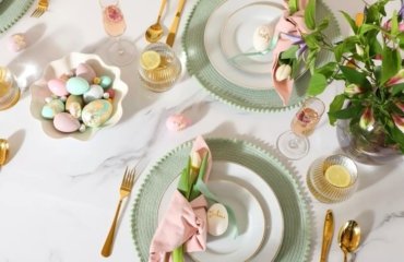 Tischdeko zu Ostern in Pastellfarben mit Blumen und gefärbten Eiern