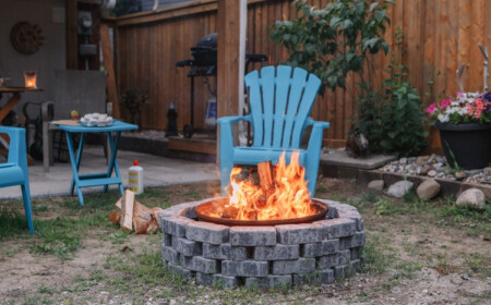 aus steinen gebaute feuerstelle inmitten eines innehofs mit angezündetem feuer