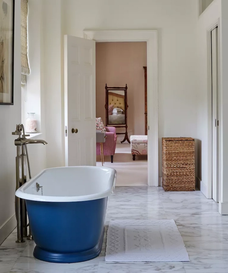 freistehende badewanne in blau bei offener tür im bad als trend