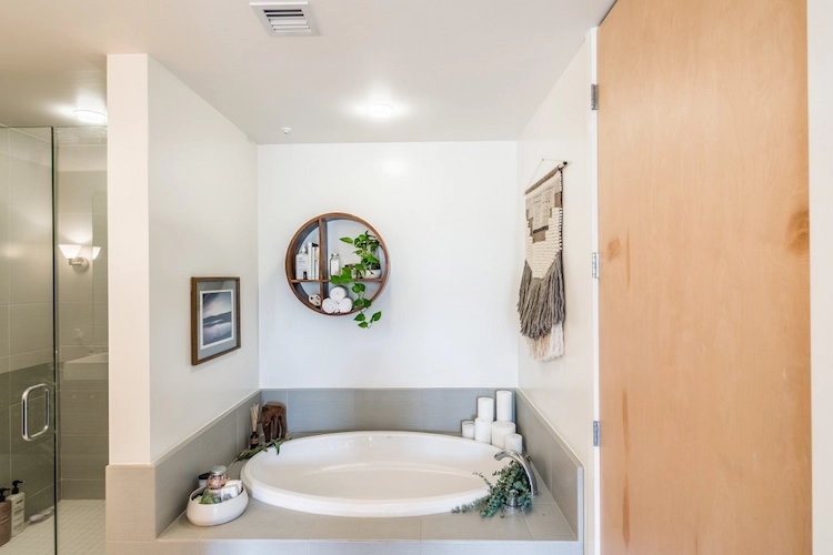 gemütlicher baderaum mit duschkabine und runder badewanne