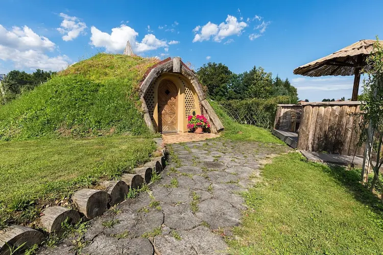 mit bepflanzung bedecktes hobbit gartenhaus im retro stil in slowenien